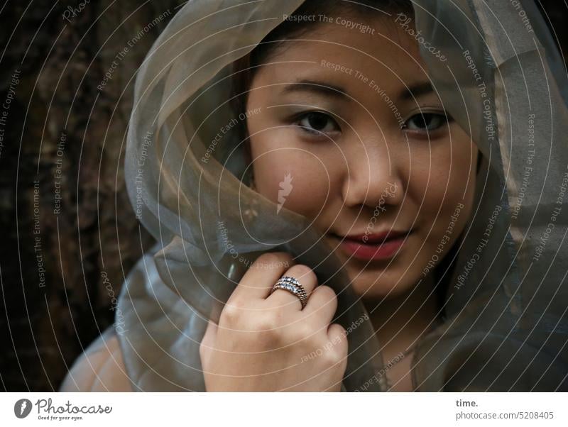 Woman with cloth portrait Rag Face Cloth Looking into the camera Feminine Smiling Mysterious Forest close out Hand Jewellery Intensive Protection