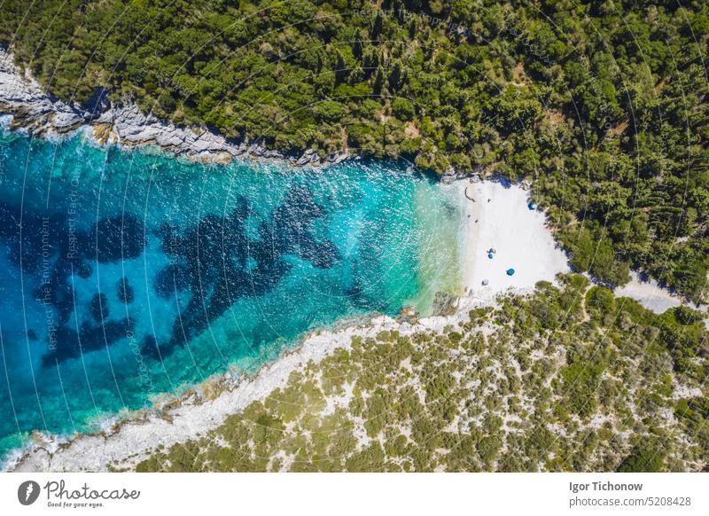 Aerial top down view of Dafnoudi beach in Kefalonia, Greece. Remote bay with pure crystal clean turquoise sea water surrounded by cypress trees greece aerial