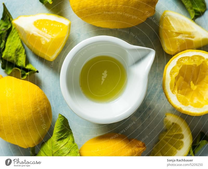 Freshly squeezed lemon juice in a bowl. Top view. Lemon Juice shell plan Slice Lemonade Fruit Summer Citrus fruits Healthy Refreshment Vitamin Yellow Cold Green
