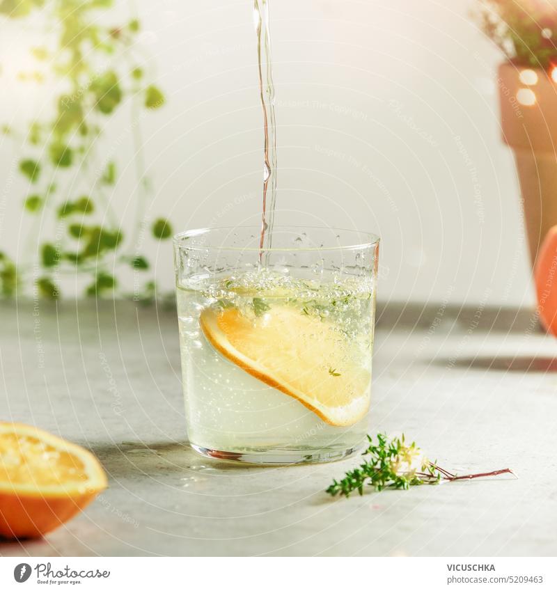 Healthy drink concept with water glass, herbs and orange slices on light table. Front view healthy drink front view ingredient homemade refreshment soda diet