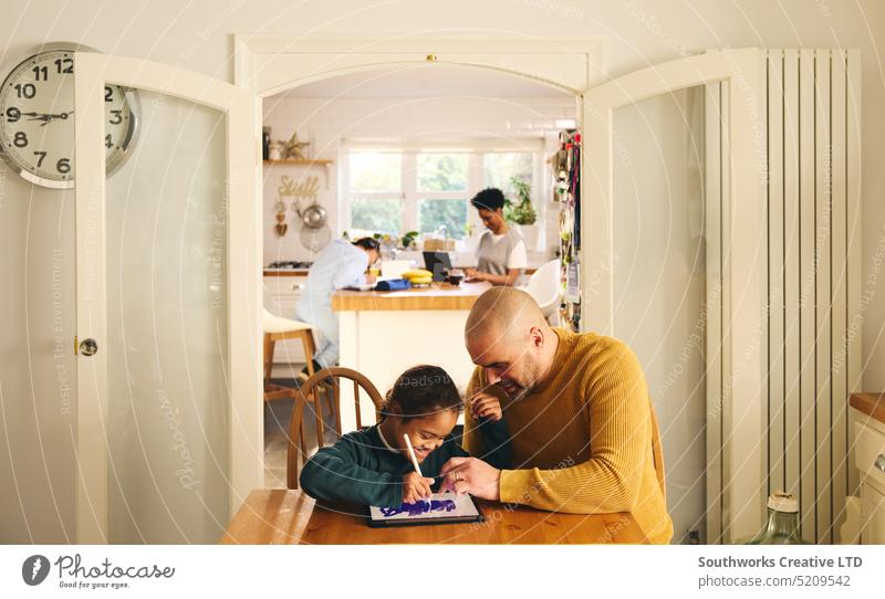 Multiracial family at home with father and son with Down syndrome using digital tablet lifestyle draw multiracial down syndrome man boy fathers day child