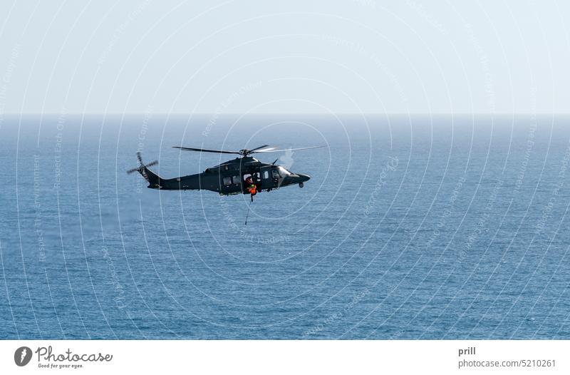 Helicopter rescue scenery helicopter rotorcraft flying sea water ocean aircraft transportation aviation flight sunny horizon italy water surface roping