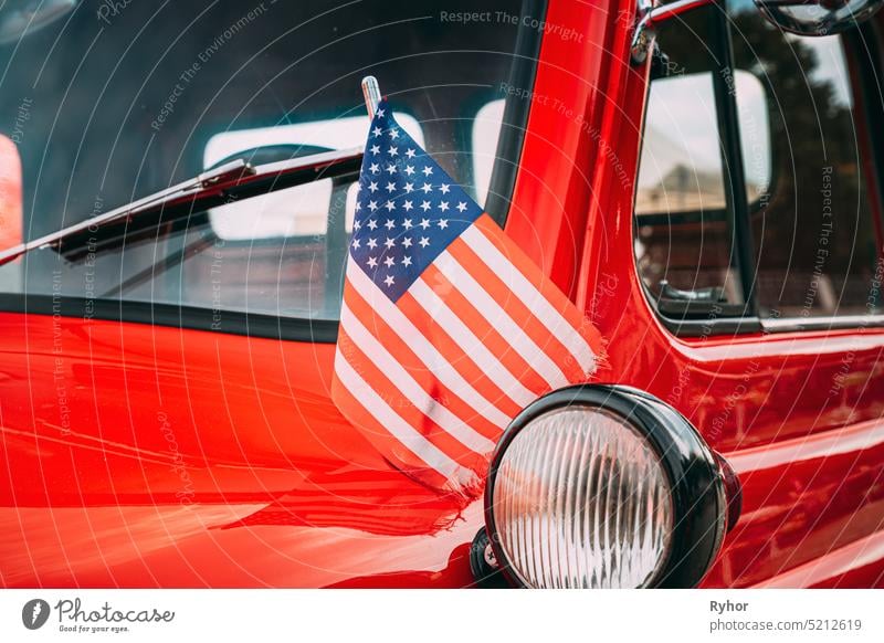 Red Pickup Truck With Small American Flag Waving. Close Side View Of Red Pickup Truck American Flag Waving. 4th of July holiday. American flag blowing in the wind. Independence Day