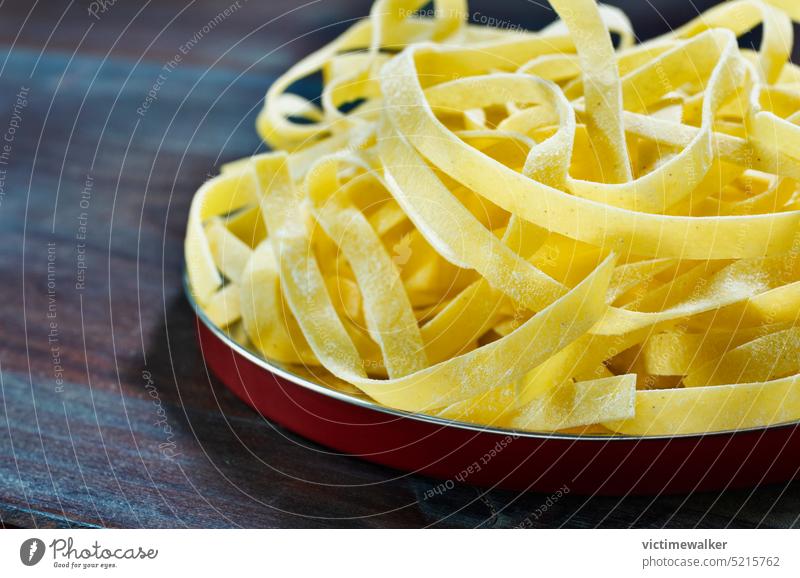 Raw fettuccine pasta on plate food cuisine copy space healthy cooking studio shot tagliatelle ingredient background traditional front view dried pasta yellow