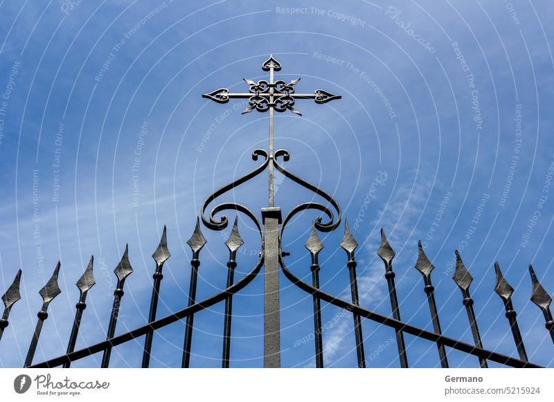 Gate with cross abstract architecture background barrier bars black blue building cemetery christian church curves decoration decorative design detail entrance