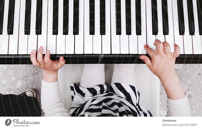 Child playing piano fun view white background young art closeup hand black top keys child fingers melody little music song sound learn school instrument kid