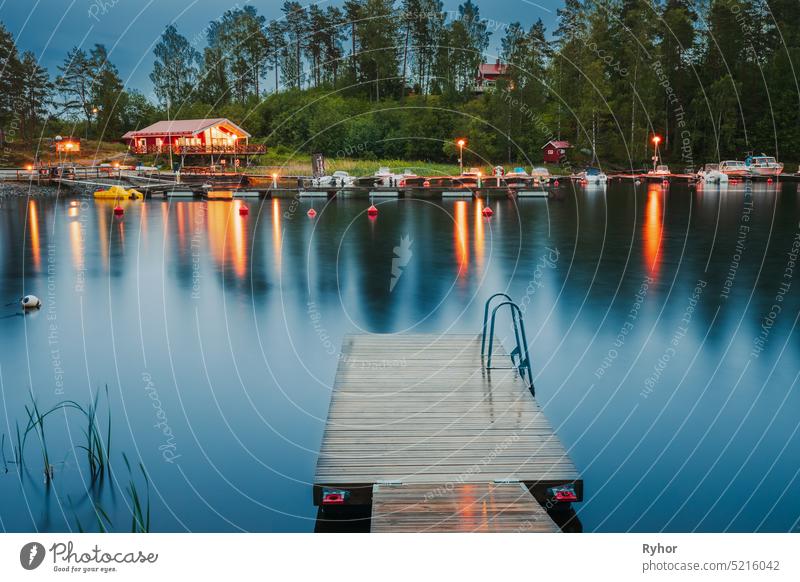 Sweden. Beautiful Wooden Pier Near Lake In Summer Evening Night. Lake Or River Landscape reflection calm summer lake beauty in nature river apartment water
