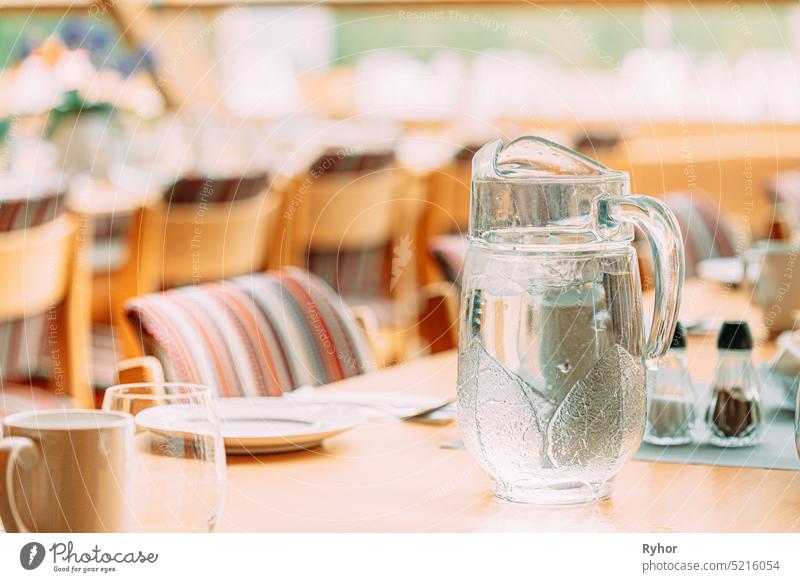 Cozy Interior Of Summer Cafe. Jug Of Icy Cold Ice Water On Table And Cutlery Laid Out ice water decoration icy bright view summer restaurant beautiful dish