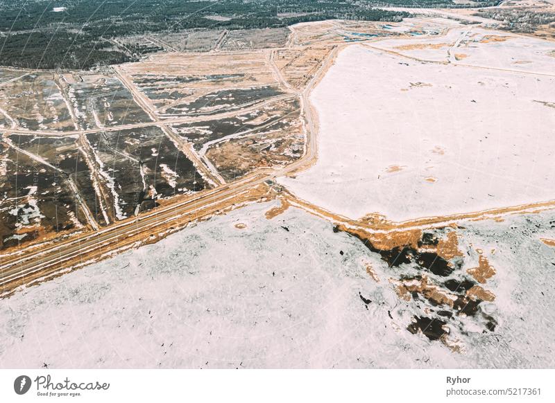 Aerial View Of Road Through Ponds In Winter Snowy Landscape. Frozen Ponds Of Fisheries In South Of Belarus. Top View Of Fish Farms From High Attitude. Drone View. Bird's Eye View