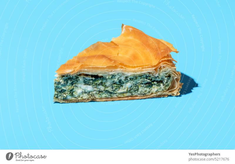 Phyllo cake slice minimalist on a blue background. Cheese and spinach pie. baked balkan banitsa bright bulgarian cheese color cuisine delicious dinner dough