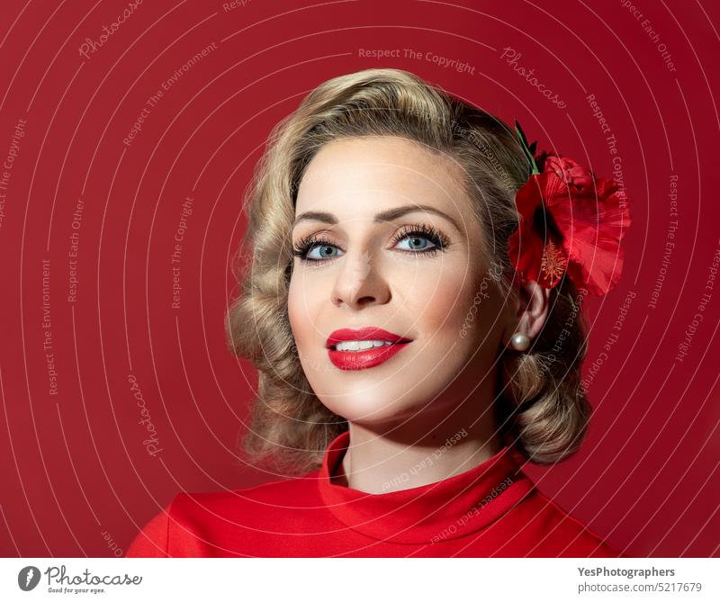 Retro hairstyle woman against a red background. Pin-up woman portrait 40s 50s beautiful beauty blonde blue bright color concept copy space curly cute elegant