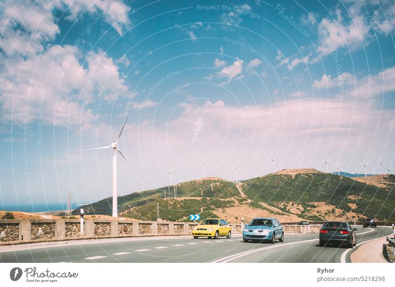 cars movement of vehicles on freeway, motorway against the background of windmills, wind turbines for electric power production. alternative asphalt blue