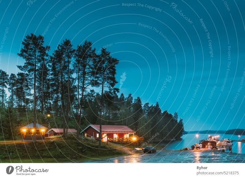 Sweden. Sweden. Beautiful Red Swedish Wooden Log Cabin House On Rocky Island Coast In Summer Night Evening. Lake Or River Landscape. Beautiful Wooden Pier Near Lake In Summer Evening Night. Lake Or River Landscape. Riverside.