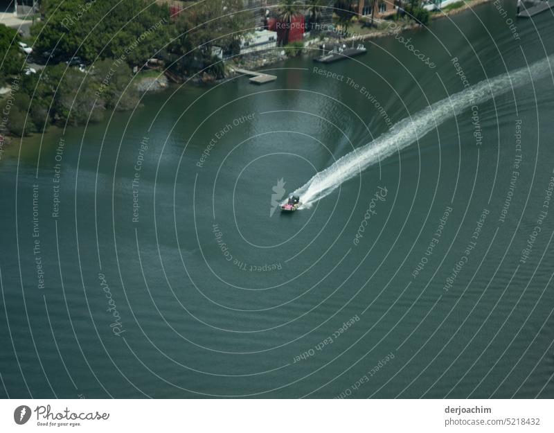 A motorboat goes at full speed across the river, leaving behind a long tail of water. . motorboat sport Day Deserted Colour photo Exterior shot Watercraft swift