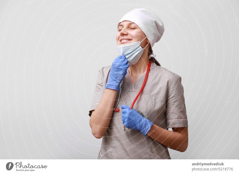 Relaxed woman breathing with the mask removed. Concept of taking off the mask.Breath pure air. ending of quarantine corona virus covid-19 concept.difficulties and problems at work of a medical worker