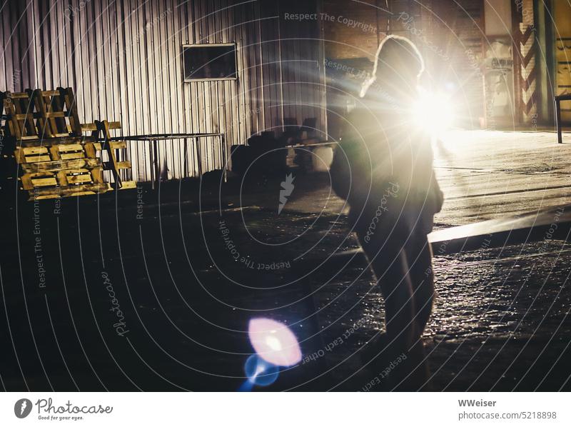 The young woman walks across a commercial courtyard at night and is illuminated by spotlights Night Courtyard Places Commerce Industry forsake sb./sth. hip