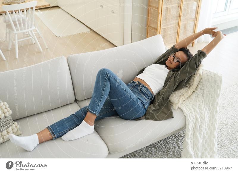 African american girl stretching after day nap, lying on comfortable sofa in living room at home african american couch serene wellness rest relax quiet female