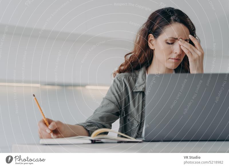 Tired frustrated employee woman works at laptop suffering from headache. Fatigue, hard working day female fatigue businessperson despair exhaustion frown hurt