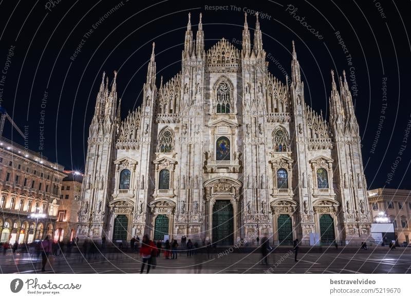 Milan, Italy low angle wide shot of illuminated gothic style Roman Catholic Duomo Cathedral facade at the homonym main square. Duomo Cathedral Milan