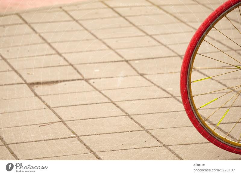Partial view of red bicycle tire with yellow spokes on paved square Bicycle Wheel tire Spokes Ride a bike! Cycling be mobile Alternative paving