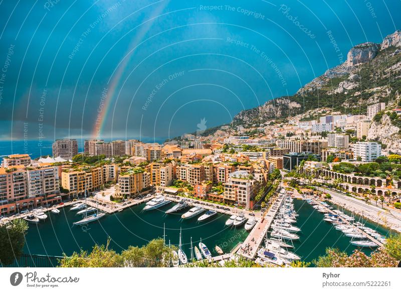 Yachts moored near city Pier, Jetty In Sunny Summer Day. Monaco, Monte Carlo architecture. Altered Sky With rainbow beautiful berth blue boat carlo cityscape