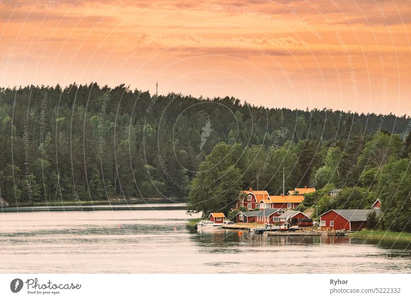 Sweden. Many Beautiful Red Swedish Wooden Log Cabins Houses On Rocky Island Coast. Lake Or River Landscape sweden house huts hygge travel nature landscape