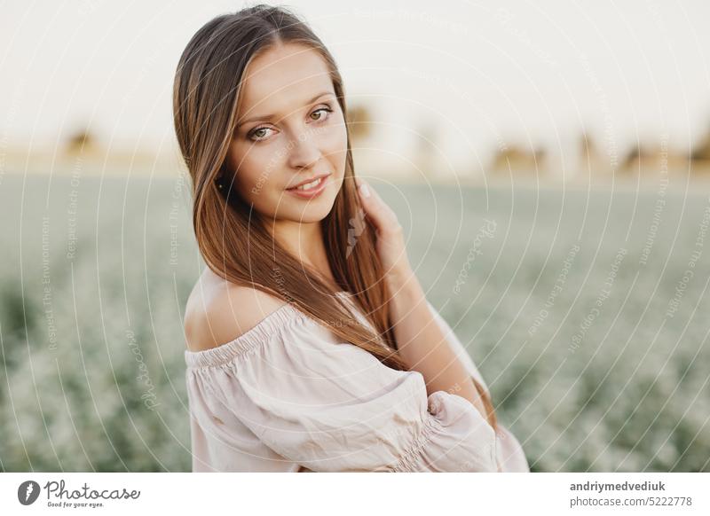 Beautiful woman enjoying field, happy young lady and spring green nature, harmony concept. portrait of a beautiful girl in a field of flowers. selective focus