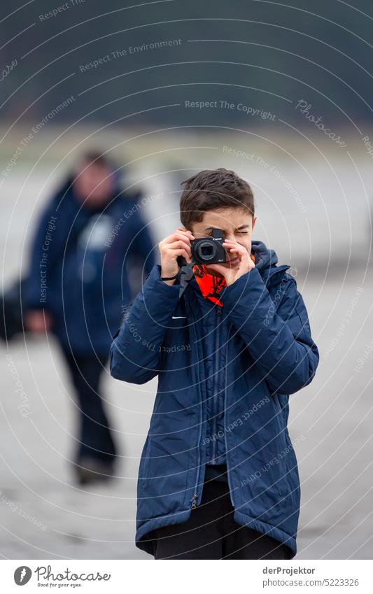 Boy taking photos on Rügen Winter mood Winter vacation Panorama (View) Light Day Copy Space middle Multicoloured Structures and shapes Subdued colour