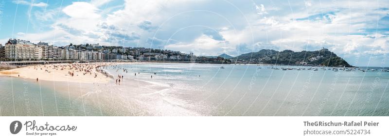 Beach with city and mountain in background Panorama (Format) People Sun houses Hill Ocean Water Sand Summer Blue Nature Bay donostia san sebastian Spain