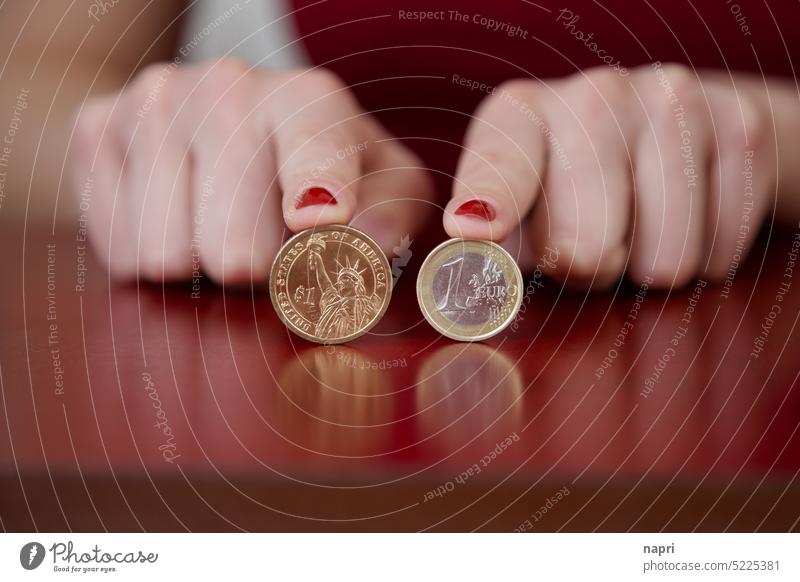 1:1 | 1 Dollar and 1 Euro coin held by index fingers with red painted fingernails on a tabletop. Money Coin dollar € $ Loose change Coins currency small change