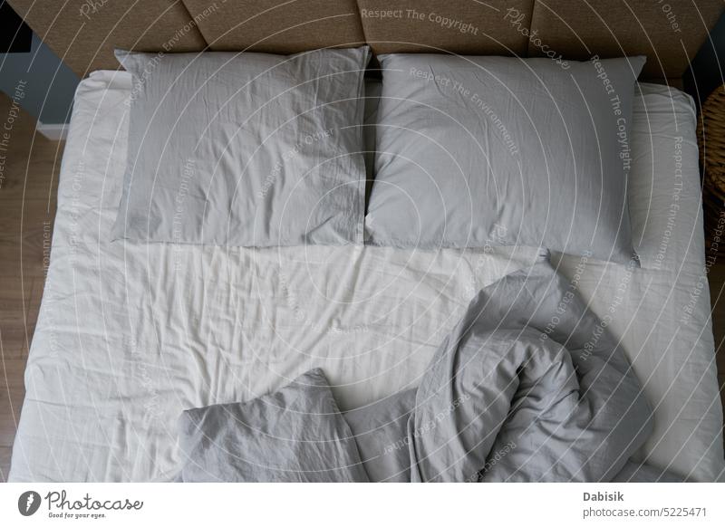 Crumpled bed with pillows, blanket and crumpled sheets in bedroom comfortable sleep household morning folds bedsheet mattress interior bright wrinkled fabric