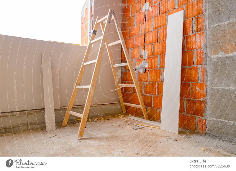 Wood ladder on building site, gypsum board leaning against on wall of blocks in unfinished edifice Apartment Block Board Brick Building Site Cable Cement