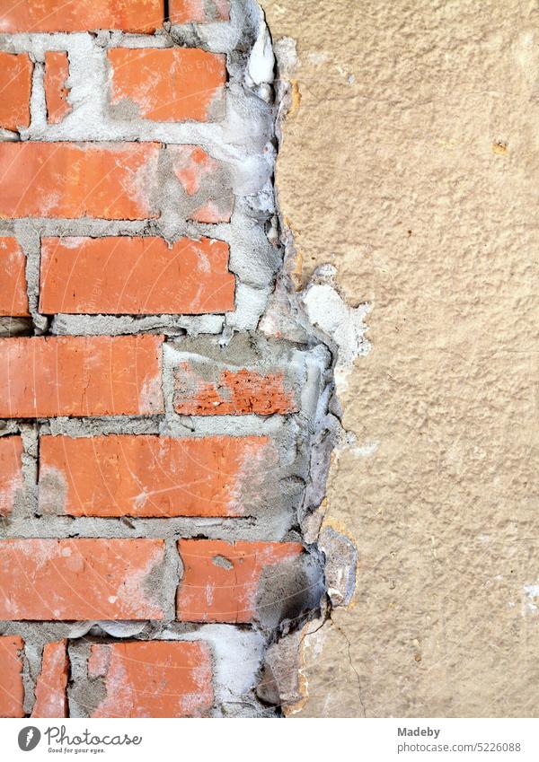 Brickwork of red-brown brick under crumbling plaster in beige and natural colors during the renovation of an old factory building in Oerlinghausen on Hermannsweg in the Teutoburg Forest in East Westphalia-Lippe