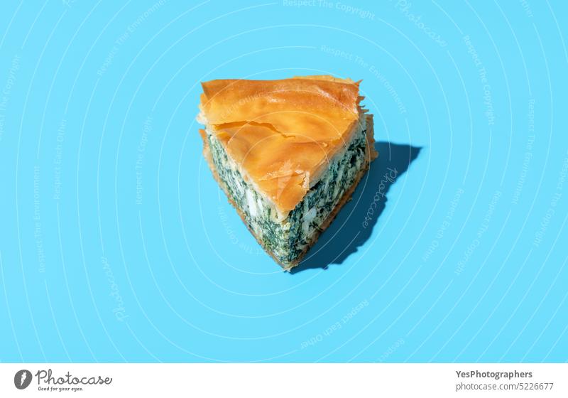 Spinach pie slice minimalist on a blue background. Homemade savory pie, balkan recipe. baked banitsa bright bulgarian cake cheese color cuisine delicious dinner
