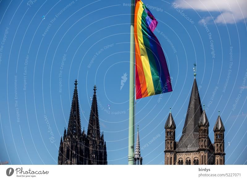 Rainbow flag in front of the Cologne Cathedral and the Benedictine Church of Great Saint Martin rainbow flag equality Gross St. Martin church LGBTQ queer