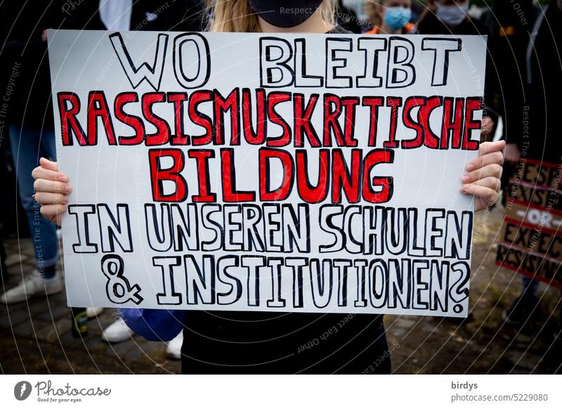 A demonstrator denounces that in German educational institutions racism is not addressed enough. thematize Schools Education education critical of racism