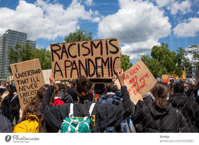 Racism is a pandemic. Protest signs at a demonstration against racism . Everyday Racism Germany Skin color Origins Fundamental rights Equal treatment