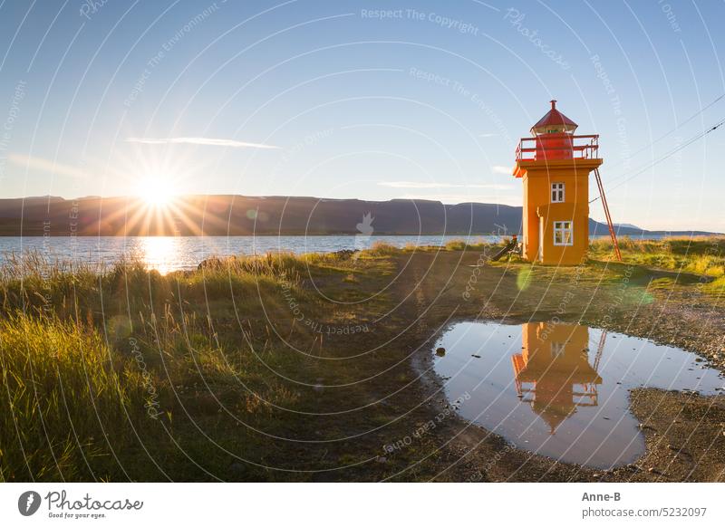 Enjoying August sun by the fjord on a bench by a bright orange lighthouse. Lighthouse Beacon luminous paint Orange Evening sun To enjoy aberrant lines Iceland