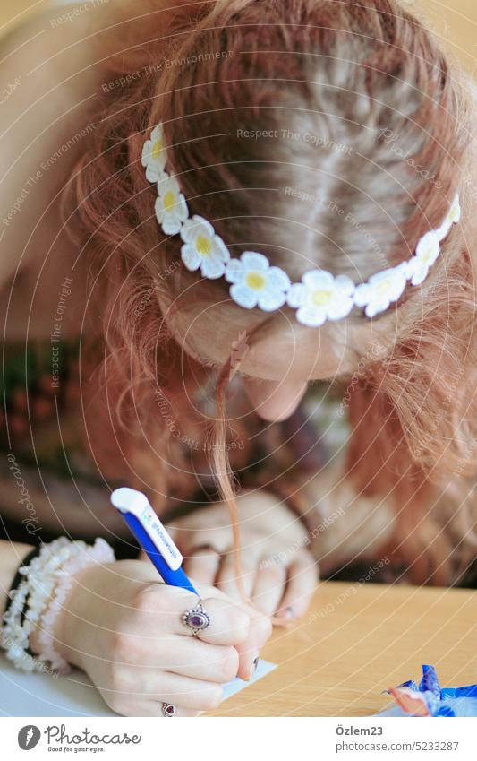 Girl with flower wreath writes a letter Flower wreath margarite Student School Letter (Mail) Write Abitur Goodbye Paper Education Study Hand Colour photo
