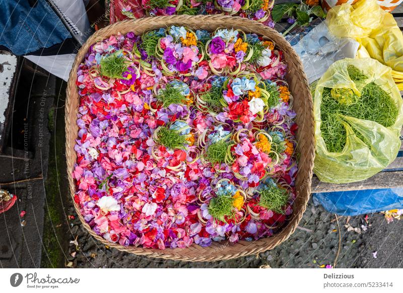 A basket full of flower petals at the market in Bali to be used for offerings flowers bali bag bags many indonesia canang colorful buy sell tradition