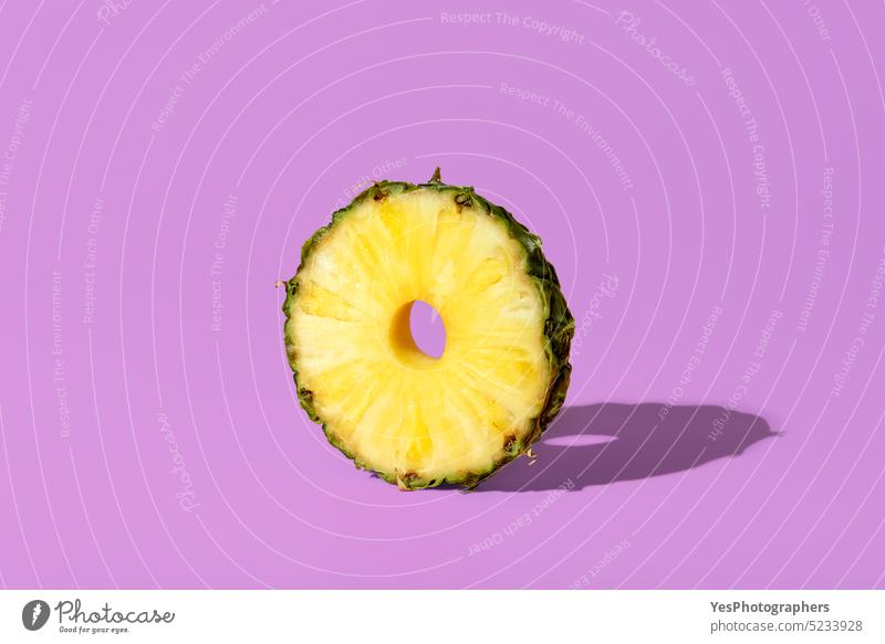 Pineapple slice isolated on a purple background. Pineapple ring in bright light. ananas circle close-up color cross section cuisine cut out delicious dessert