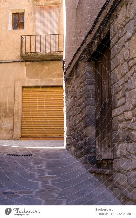 Alley of a Catalan town, stone wall, garage door and light frame Town Village Catalonia Wall (barrier) Stone Stone wall Garage Garage door Light Frame Brown