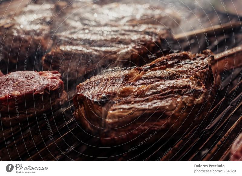 Some excellent pieces of Argentinian beef on a charcoal grill appetizing background barbecue barbeque barbequing bbq bone-in braai closeup cooked cooking