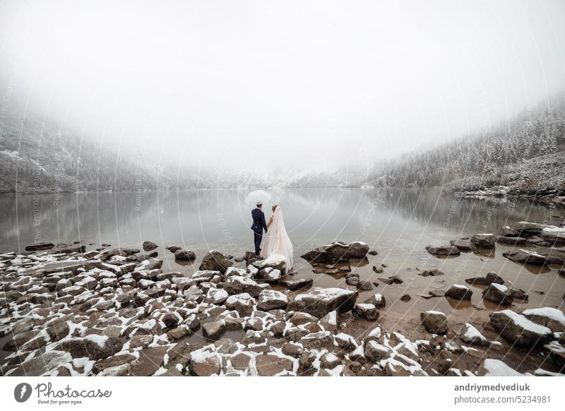 brides mountain near the lake in winter. Tender couple in love. frozen landscape nature wedding cold happiness hill happy outdoor caucasian beauty snow alpine