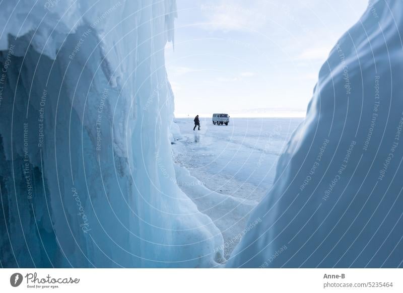 nice and cold on Lake Baikal, view from a cave onto the ice surface on which a person and a car can be seen. Cold icily Ice Blue chill Car on the ice frozen