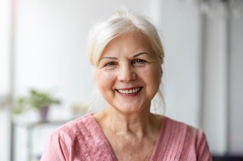 Portrait of smiling senior woman looking at camera real people indoors loft window home mature adult one person attractive successful confident beautiful female