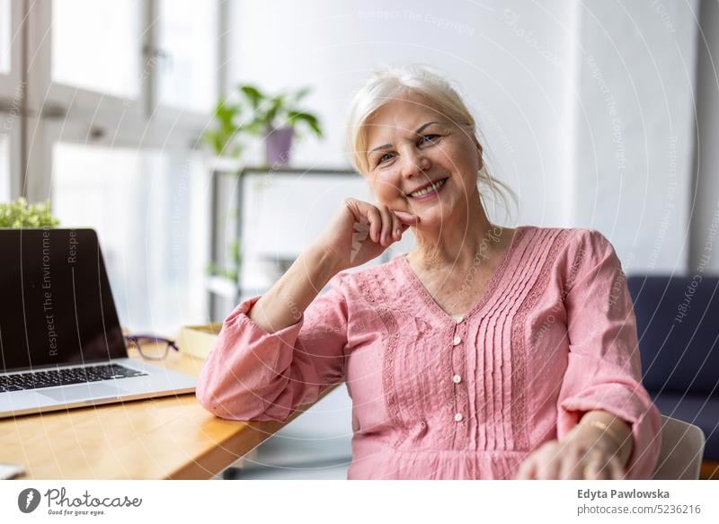 Portrait of smiling senior woman looking at camera real people indoors loft window home mature adult one person attractive successful confident beautiful female