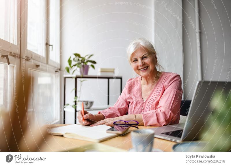 Portrait of smiling mature businesswoman working in an office real people senior indoors loft window home mature adult one person attractive successful