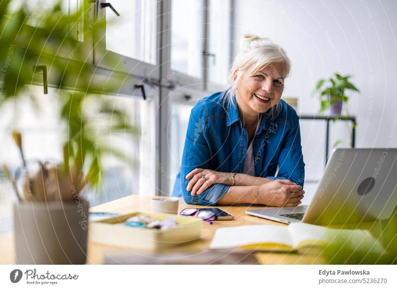 Portrait of smiling mature businesswoman working in an office real people senior indoors loft window home mature adult one person attractive successful