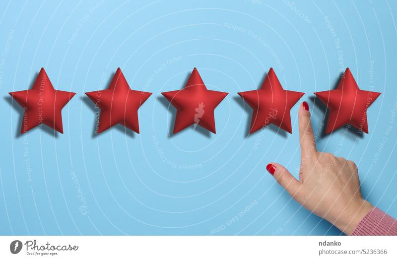 Five red stars and a hand on a blue background. Evaluation of the quality of services and goods, high rating review best reputation result satisfaction score